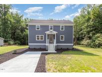 Charming two-story home with gray siding, a concrete driveway and a welcoming front porch at 1605 Bobwhite Ln, Rocky Mount, NC 27804