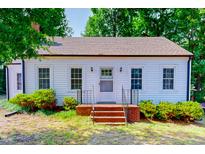 Charming cottage-style home featuring white siding and a welcoming front entrance with brick steps at 171 Magnolia Dr, Roxboro, NC 27573