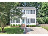 Charming two-story home with a well-manicured lawn and a welcoming front entrance with a teal-colored front door at 1905 Indianwood Ct, Raleigh, NC 27604