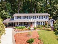 Two-story home featuring a covered porch, manicured landscaping, and elegant architectural details at 4021 Converse Dr, Raleigh, NC 27609