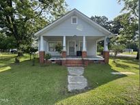 Charming home with a welcoming front porch, brick accents, and a well-maintained lawn at 429 5Th & Brogden Rd, Smithfield, NC 27577