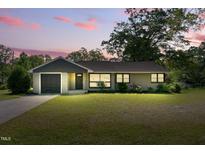 Charming home featuring a well-manicured lawn and an attached garage with a cozy and inviting appeal at 492 N Dunn St, Angier, NC 27501