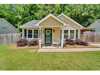 Charming single-story home featuring a cozy front porch and lush, well-maintained landscaping at 512 Wyndham Dr, Fuquay Varina, NC 27526