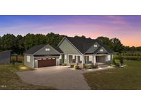 Charming home featuring a covered porch and well-manicured landscaping at 540 Pine Ridge Rd, Zebulon, NC 27597
