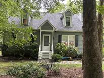 Charming two-story home features a welcoming front porch, complemented by mature landscaping and lovely curb appeal at 5816 Henner Pl, Durham, NC 27713
