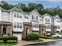 Attractive townhome exteriors featuring stone accents, neutral siding, garage, and tidy landscaping at 6206 Braidwood Court Ct, Raleigh, NC 27612