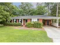 Charming single-story brick home with well-maintained landscaping and a convenient attached carport at 780 Leslie Campbell Ave, Lillington, NC 27546