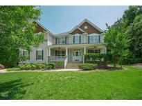 Charming two-story home with inviting front porch and meticulously landscaped lawn at 1005 Hidden River Ct, Raleigh, NC 27614