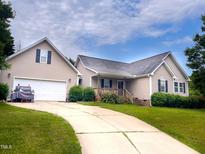 Charming home featuring a two-car garage, well-manicured lawn, and inviting curb appeal at 101 Langston Ridge Dr, Angier, NC 27501