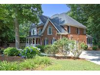 Beautiful two-story brick home with manicured lawn and lush landscaping in a serene, wooded setting at 101 Royal Glen Dr, Cary, NC 27518