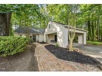 Charming exterior of a home with a brick walkway and lush landscaping at 107 Wimbledon Ct, Cary, NC 27511