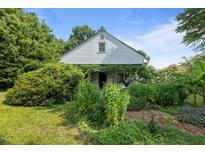 Charming home with abundant greenery and foliage covering the front exterior, offering a serene curb appeal at 1090 S Fifth St, Mebane, NC 27302