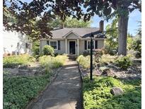 Charming home featuring a landscaped front yard with stone walkway, decorative lighting and lush greenery at 117 Georgetown Rd, Raleigh, NC 27608