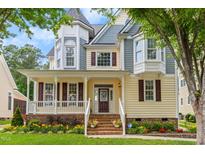 Charming two-story home with a welcoming front porch and beautifully landscaped front yard at 121 Fort Jackson Rd, Morrisville, NC 27560