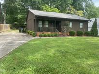 Charming single-story home with a well-maintained lawn, inviting front porch, and mature trees at 1913 Rendall St, Burlington, NC 27215