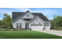 Charming two-story home featuring a three-car garage, light blue siding and a well-manicured lawn at 2129 Abbeyhill Dr # 89, Raleigh, NC 27610