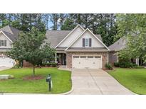 Charming home with stone accents, two-car garage, well-maintained lawn, and inviting landscaping at 260 Easy Wind Ln, Garner, NC 27529