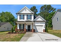 Charming two-story home with a covered porch, attached garage, and well-maintained landscaping at 325 Bluejay St, Clayton, NC 27520