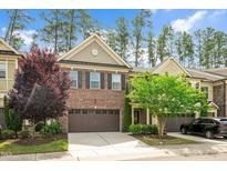 Charming brick townhome featuring a two-car garage and well-maintained landscaping at 329 Castle Rock Ln, Cary, NC 27519