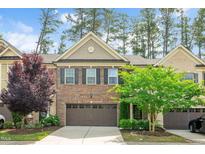 Charming brick townhome with a two-car garage and well-maintained landscaping at 329 Castle Rock Ln, Cary, NC 27519