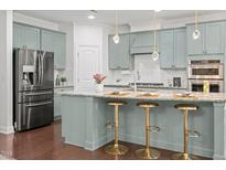 Charming kitchen featuring stainless steel appliances, granite countertops, and stylish island seating at 329 Castle Rock Ln, Cary, NC 27519