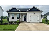 Charming one-story home featuring a covered porch, attached garage, and well-maintained landscaping at 335 Bluejay St, Clayton, NC 27520