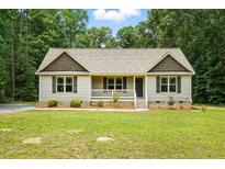 Charming single-story home with a cozy front porch and well-manicured lawn surrounded by mature trees at 39 Blue Heron Ct, Kenly, NC 27542