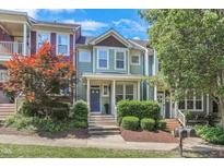 Charming townhouse with a cozy front porch, beautiful landscaping, and colorful trees at 412 Heritage Village Ln, Apex, NC 27502