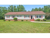 Charming ranch-style home with red shutters, a well-manicured lawn, and mature trees, perfect for a serene living at 4403 Jeffries Rd, Durham, NC 27704