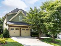 Charming home featuring a two-car garage, stone accents, and a well-manicured lawn at 612 Peach Orchard Pl, Cary, NC 27519