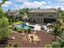 This backyard oasis has a pool, cabana, outdoor seating, and a fire pit, perfect for entertaining at 814 Covered Bridge Trl, Chapel Hill, NC 27517