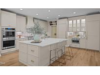 Bright kitchen featuring a spacious island with quartz countertop, stainless steel appliances, and light wooden floors at 814 Covered Bridge Trl, Chapel Hill, NC 27517