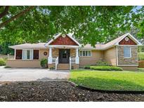 Charming single-story home with a unique facade, decorative trim, and lush greenery at 821 Woodburn Rd, Raleigh, NC 27605
