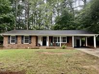 Charming brick home with a covered front porch and manicured lawn at 1006 Aversboro Rd, Garner, NC 27529
