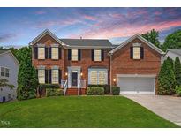 Charming two-story brick home with manicured lawn and beautiful landscaping at 104 Trinity Grove Dr, Cary, NC 27513