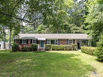 Charming brick home featuring a landscaped front yard and a covered carport area at 114 Brenrose Cir, Durham, NC 27705