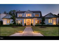 Stunning home with manicured lawn, lush landscaping and inviting entryway at dusk at 115 Founders Ridge Dr, Chapel Hill, NC 27517