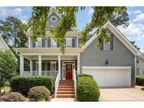 Charming two-story home with a red front door, covered porch, and landscaped front yard at 1230 Golden Bluff Ln, Fuquay Varina, NC 27526