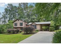Charming two-story home with neutral paint, mature landscaping and a covered portico leading to the driveway at 1308 Swallow Dr, Raleigh, NC 27606