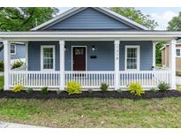 Charming blue home with a welcoming front porch and manicured landscaping at 1318 N Alston Ave, Durham, NC 27701