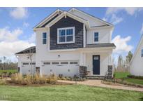 Charming two-story home featuring a brick walkway and a three-car garage, perfect for a growing Gathering at 157 Vaughan Farms Drive Dr, Angier, NC 27501