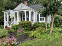 Charming cottage-style home featuring a welcoming front porch, well-manicured landscaping, and classic architectural details at 1615 Bickett Blvd, Raleigh, NC 27608