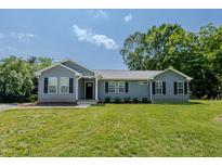 Charming single-story home featuring blue siding, black shutters, and a well-manicured lawn at 169 Forest Dr, Graham, NC 27253