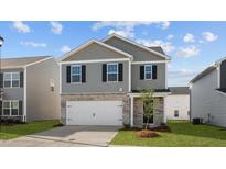 Charming two-story home featuring a two-car garage, gray siding, and well-manicured lawn at 2122 Monk Dr, Haw River, NC 27258