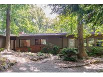 Charming single-story home with a brick accent, mature trees, and natural landscaping at 26 Mt. Bolus Rd, Chapel Hill, NC 27514