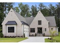 Stunning brick home boasts a manicured lawn, attached garage, and stately architectural details at 2713 Trifle Lane Ln, Wake Forest, NC 27587