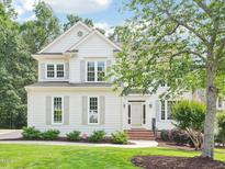 Charming two-story home boasts a meticulously landscaped front yard and classic architectural details at 305 Promontory Point Dr, Cary, NC 27513
