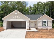 Charming one-story home featuring an attached two-car garage and neutral siding, awaiting your personal touch at 311 Rothbury Ct, Sanford, NC 27330
