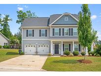 Charming two-story home features a manicured lawn and attached two-car garage at 33 E Ravano Dr, Clayton, NC 27527