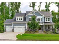 Inviting blue two-story home with stone accents, three-car garage, and well-maintained lawn at 4105 Bankshire Ln, Raleigh, NC 27603
